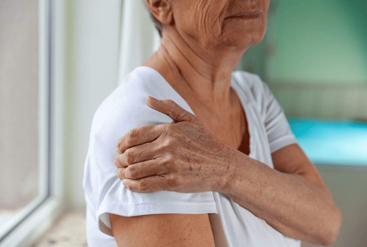 senior woman holding shoulder in discomfort