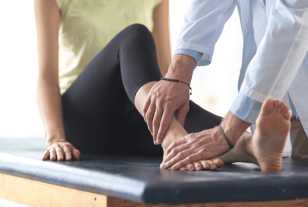 medical professional examining female patient's foot