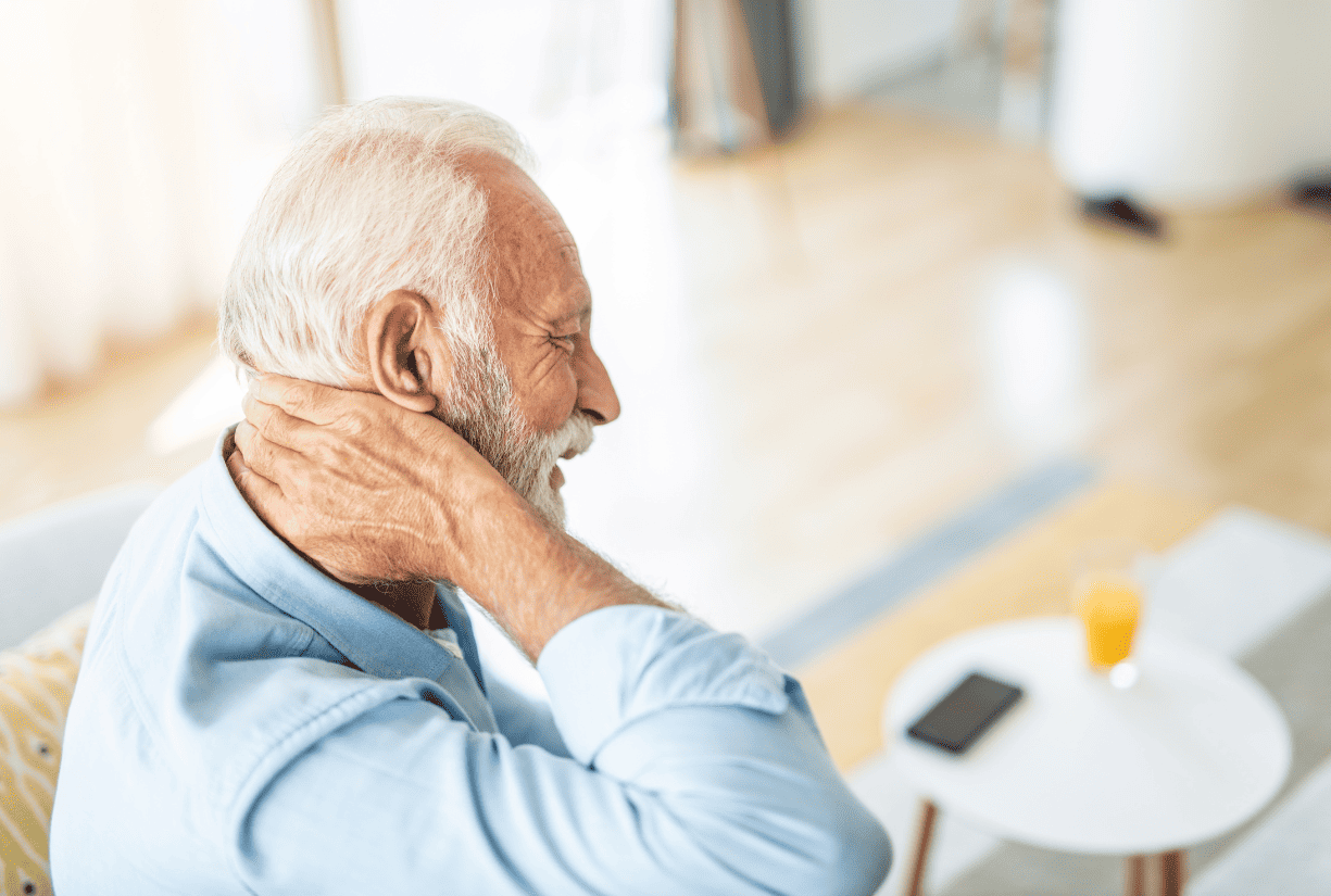 senior man holding back of neck in pain