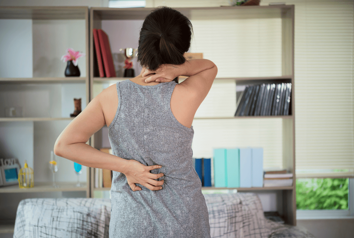 woman reaching for back and back of neck in pain