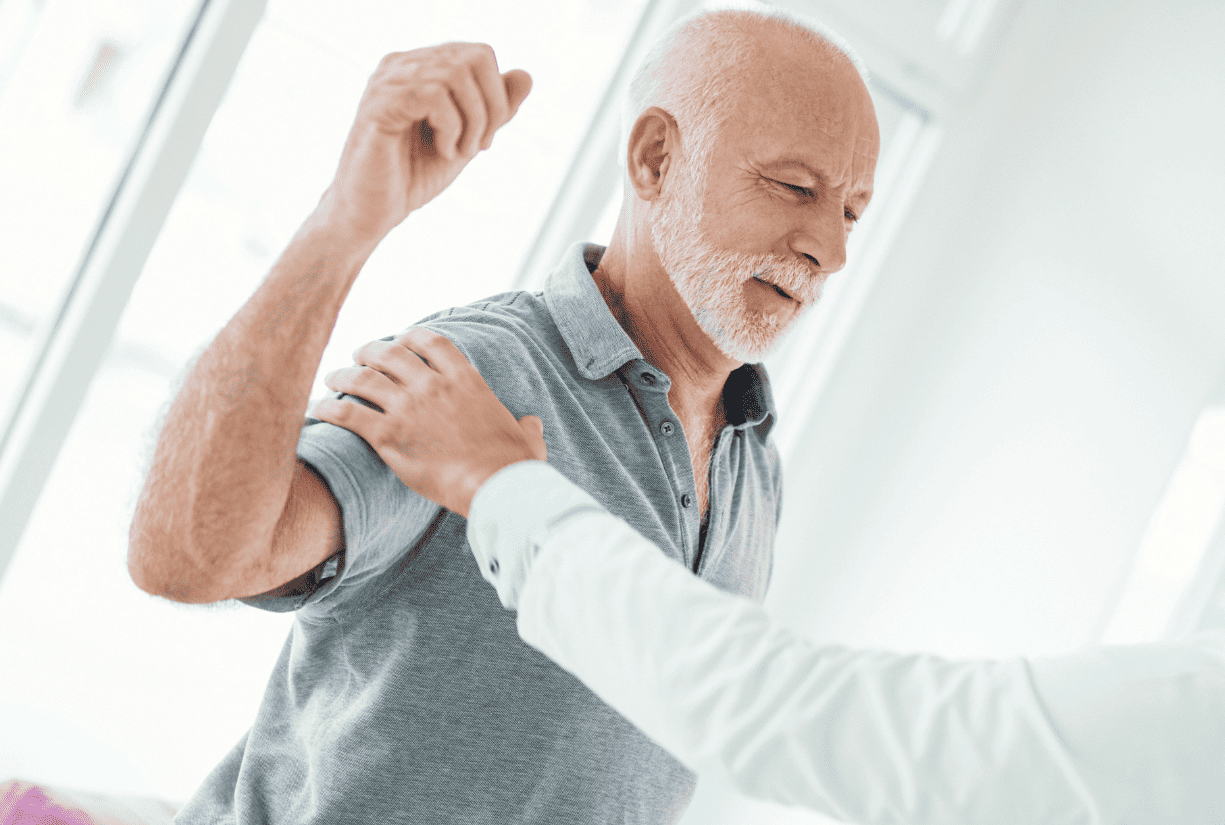 medical professional examining the shoulder and arm of senior citizen