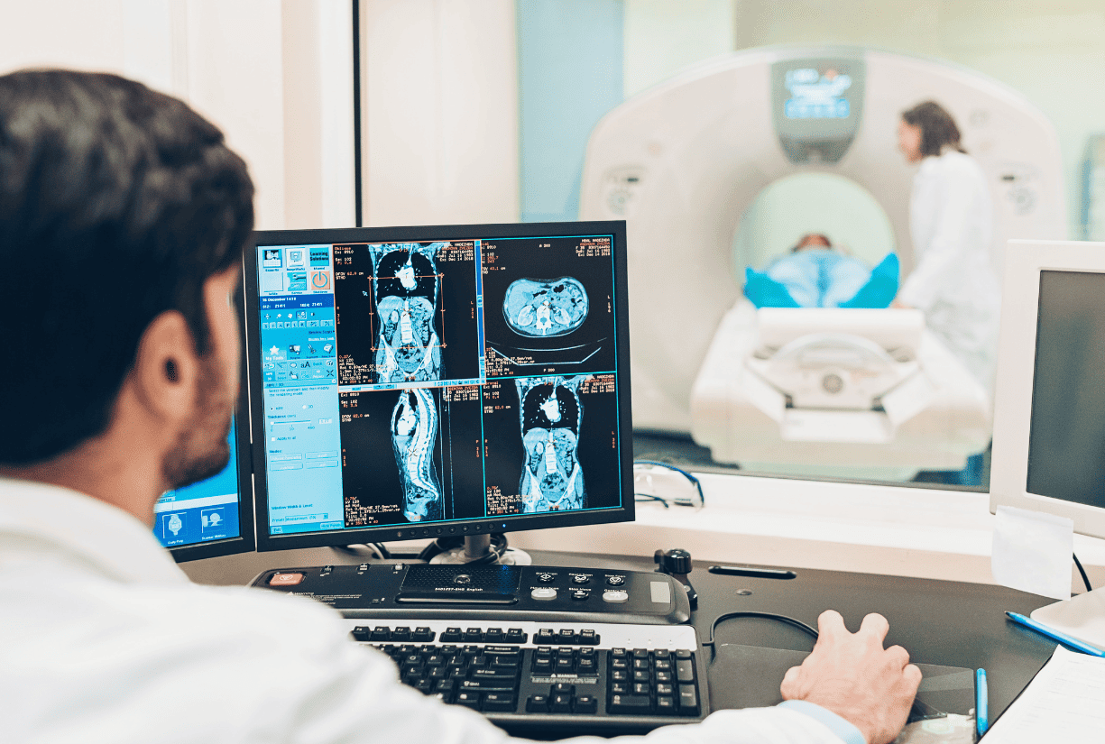 medical professionals doing MRI on patient and checking results on computer