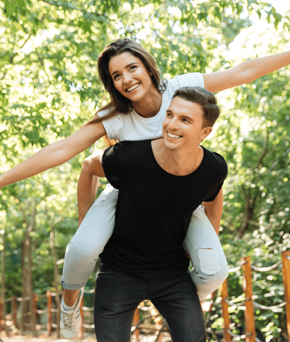 Young smiling couple enjoying piggyback ride and laughing