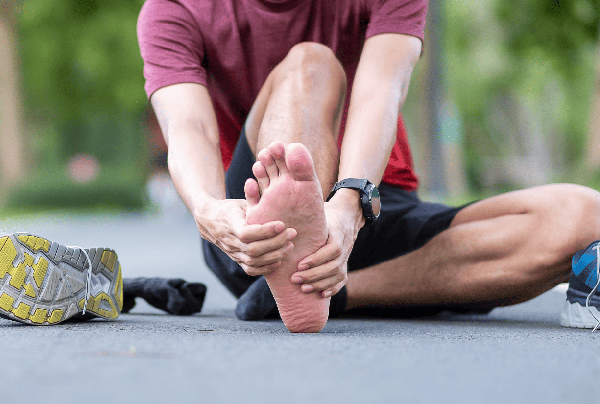 man sitting outside with shoes off due to some kind of foot pain