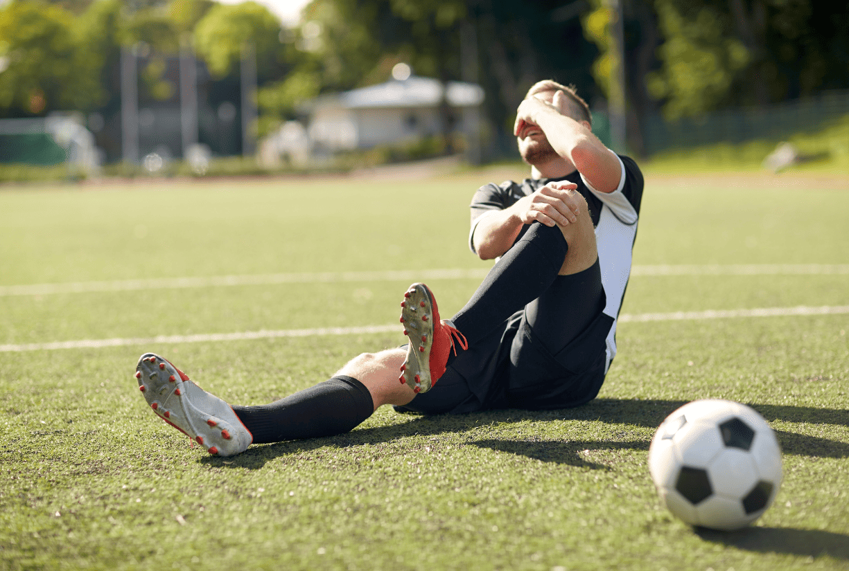 soccer play on field holding knee in pain