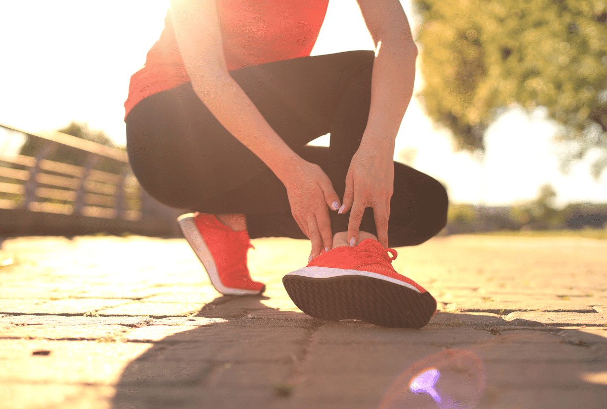 woman in holding ankle outdoors