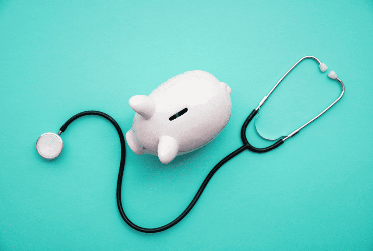 Downward view of a stethoscope and piggy bank
