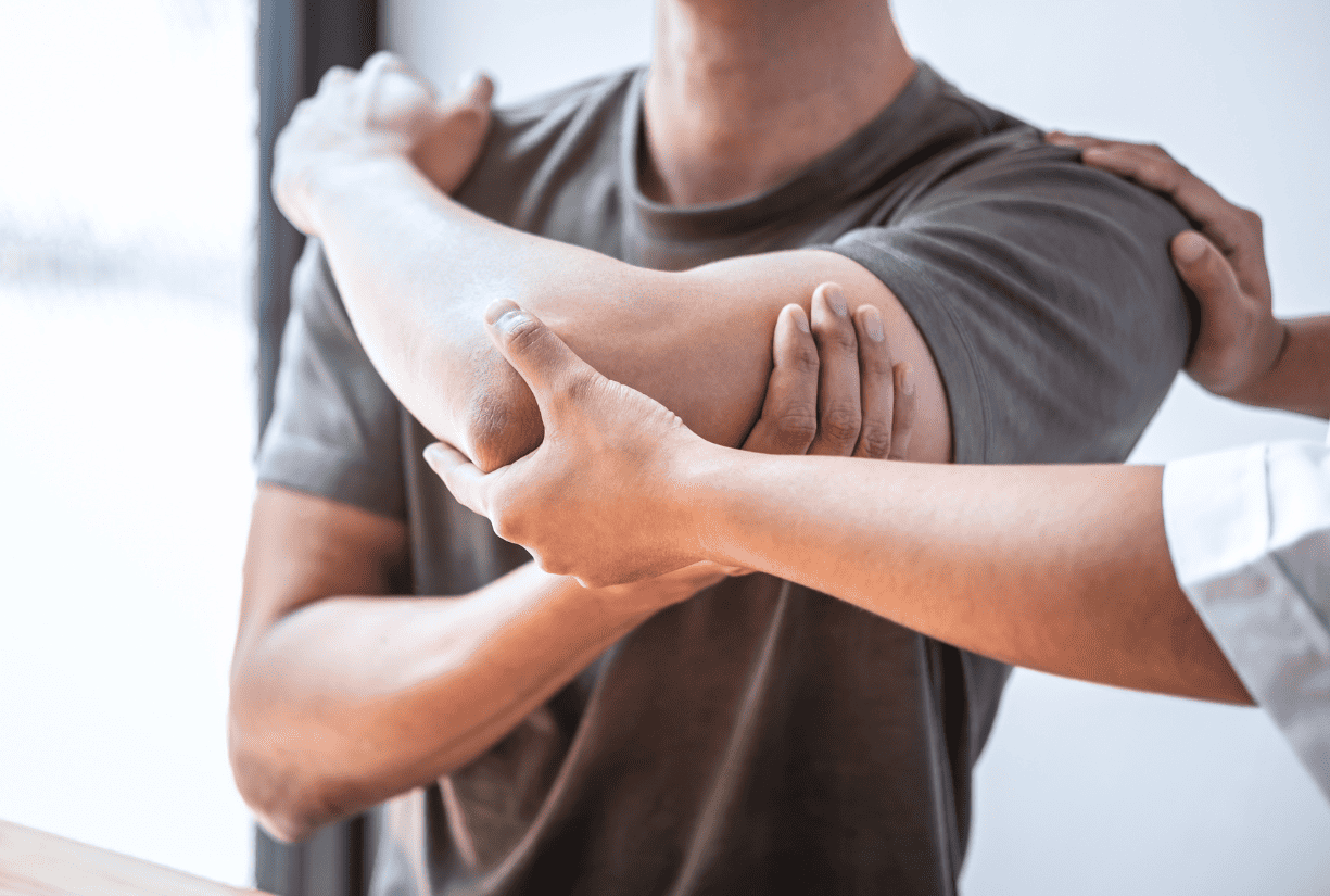 medical professional stretching and examining patient arm and shoulder