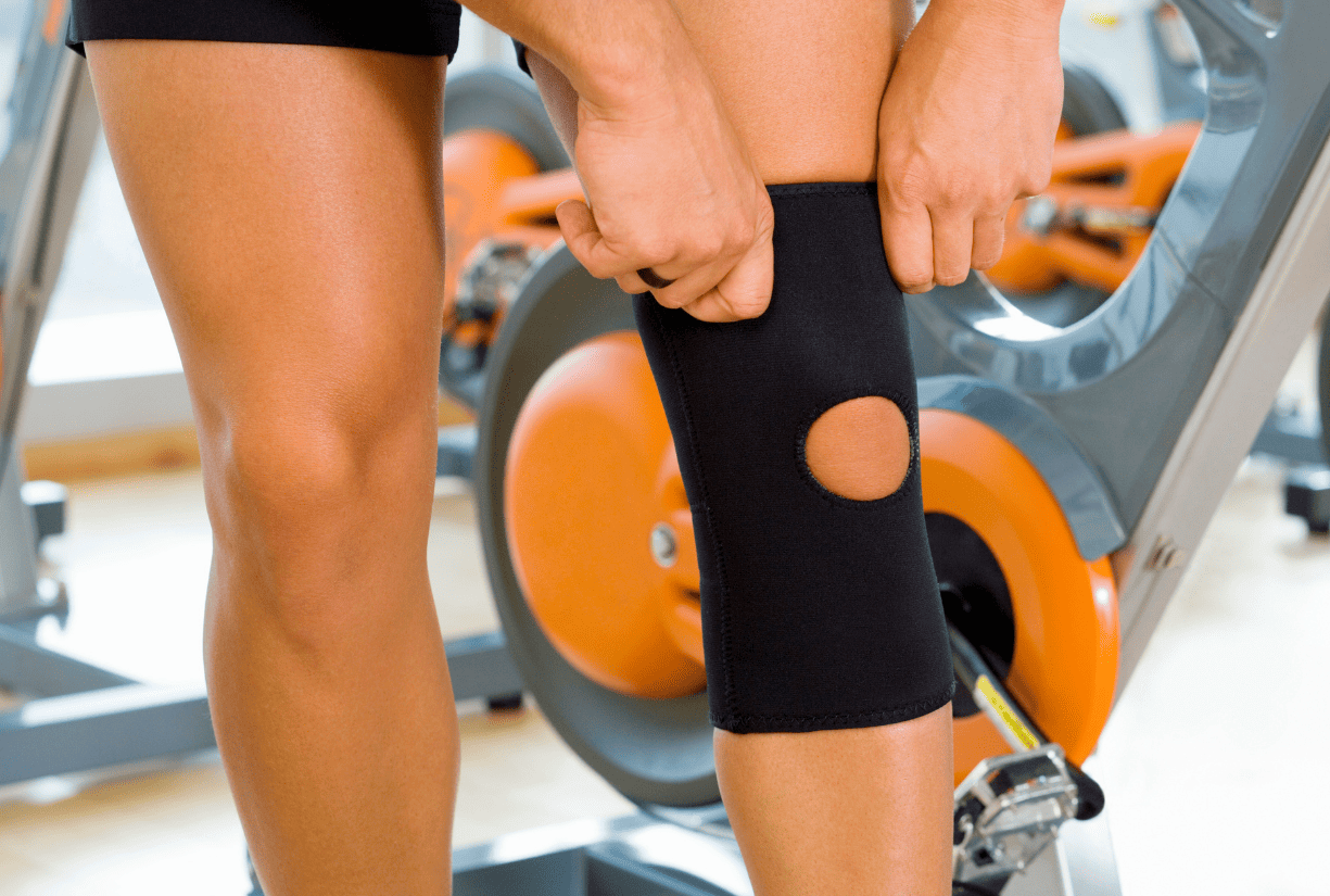 woman in gym putting on knee brace