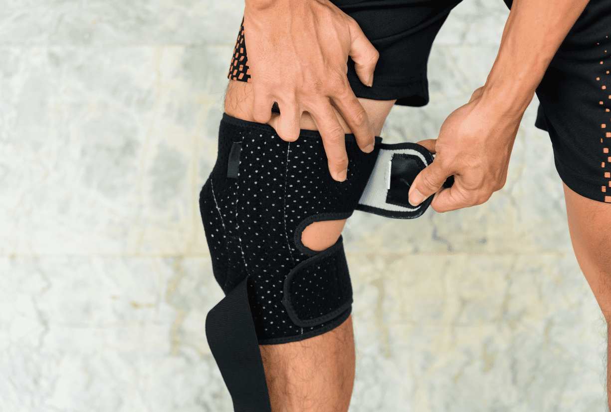 man applying knee brace