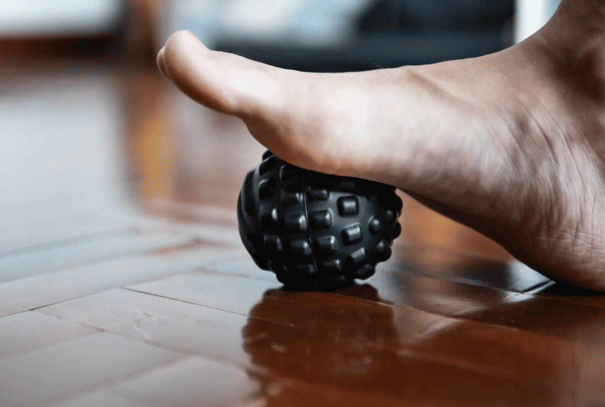 foot rolling on rubber massage ball