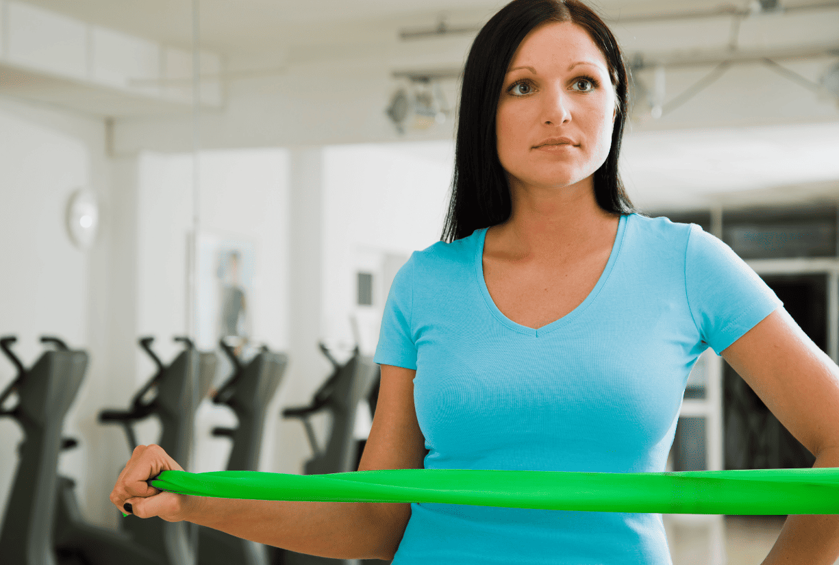 woman doing band pilates in gym