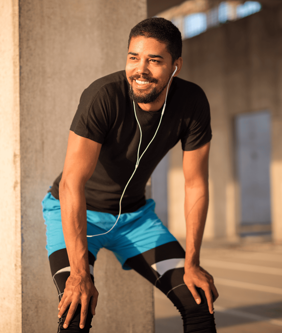 smiling man in athletic tights with headphones